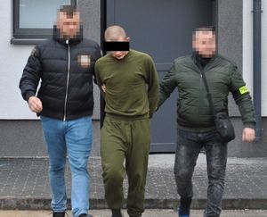 fot. zatrzymany 20-latek doprowadzany przez policjantów