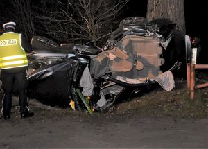 policjant i uszkodzony samochód na miejscu wypadku