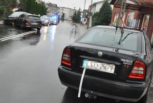 stojące na jezdni uszkodzone samochody marki Skoda, Volkswagen i Peugeot, w tle radiowóz z włączonymi światłami pojazdu uprzywilejowanego