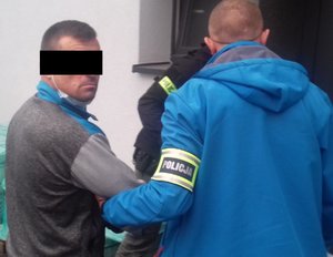 nieumundurowani policjanci prowadzą podejrzanego