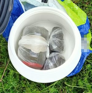 plastikowe wiadro ze słoikiem i workami foliowym z zawrtością narkotyków