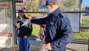 policjant daje mężczyźnie maseczkę